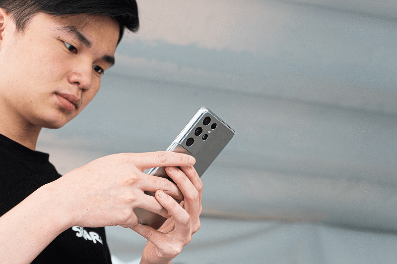 Personne utilisant activement le Samsung Galaxy S21, illustrant son utilisation intuitive et sa connectivité rapide.