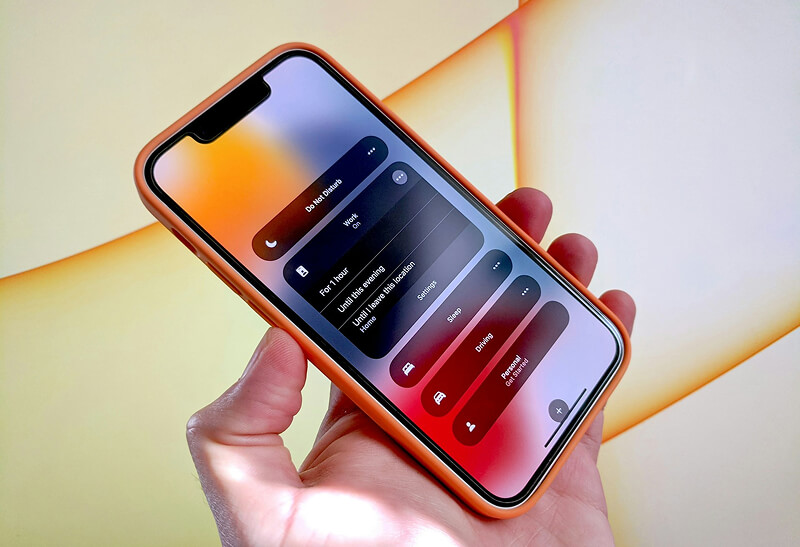 iPhone 13 mini sous iOS 18 avec écran allumé.