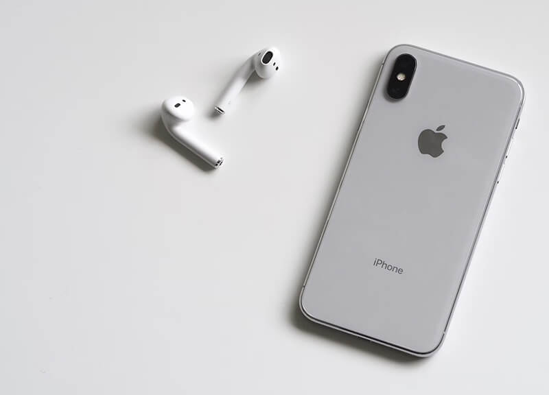 iPhone X avec des Airpods symbolisant ses capacités audio.
