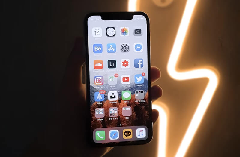 Écran de l'iPhone X affichant l'interface iOS avec des icônes d'applications.