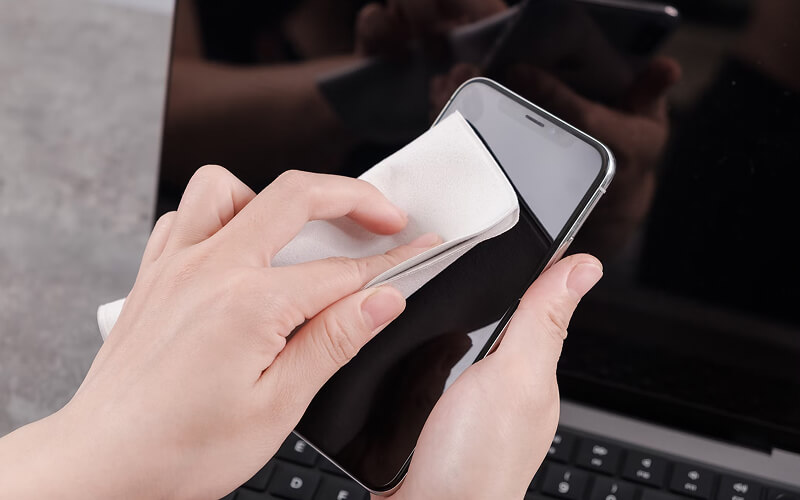 iPhone X en train d'être nettoyé en atelier de reconditionnement, symbolisant l'achat responsable.