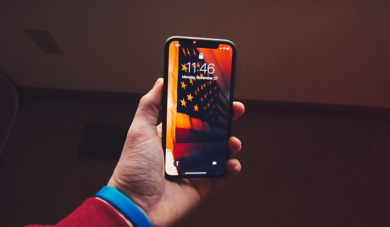 Écran de l'iPhone X affichant l'interface iOS avec des icônes d'applications.