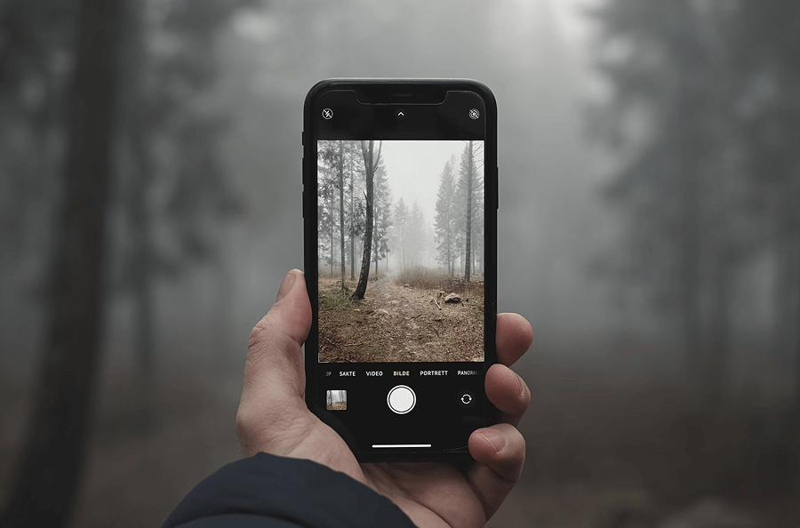 Une personne utilisant un iPhone XR pour prendre une photo, mettant en avant les capacités photographiques de l'appareil.