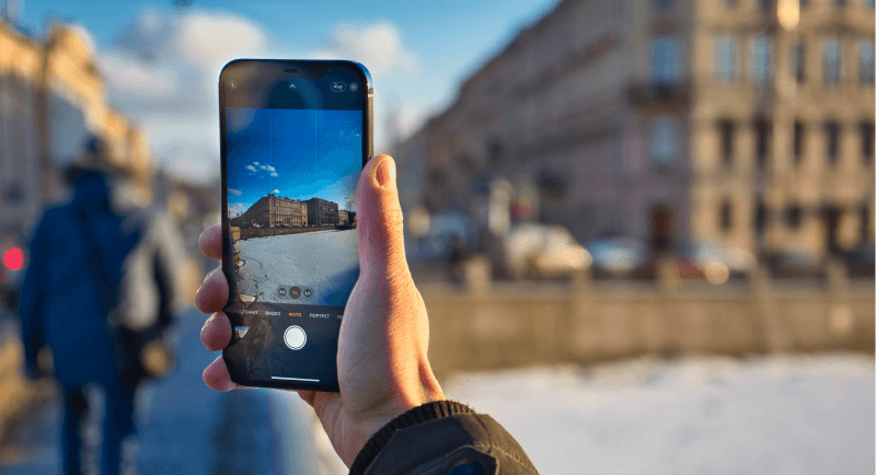 Utilisateur en train de prendre un batiment en photo avec son iPhone 12