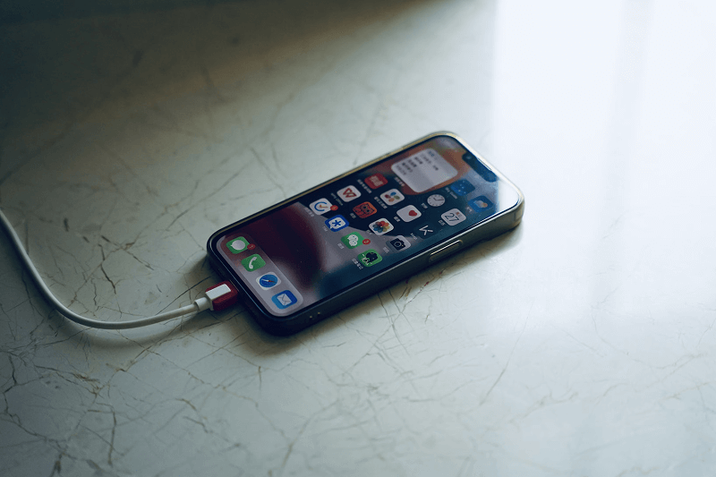 Un iPhone 13 en train de charger avec son port Lightning
