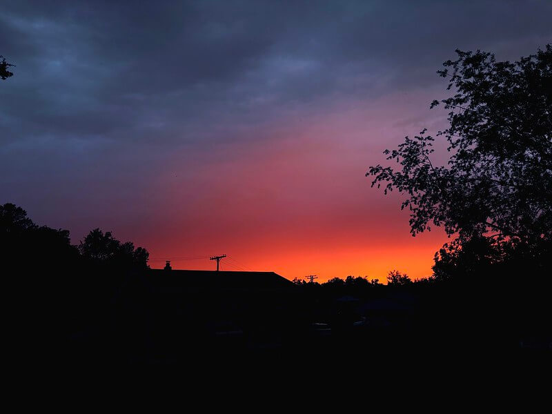 Excellence en basse lumière : cliché de nuit par l'iPhone 16 révélant les couleurs du coucher de soleil malgré le premier plan sombre, prouvant la gestion dynamique de l'exposition.