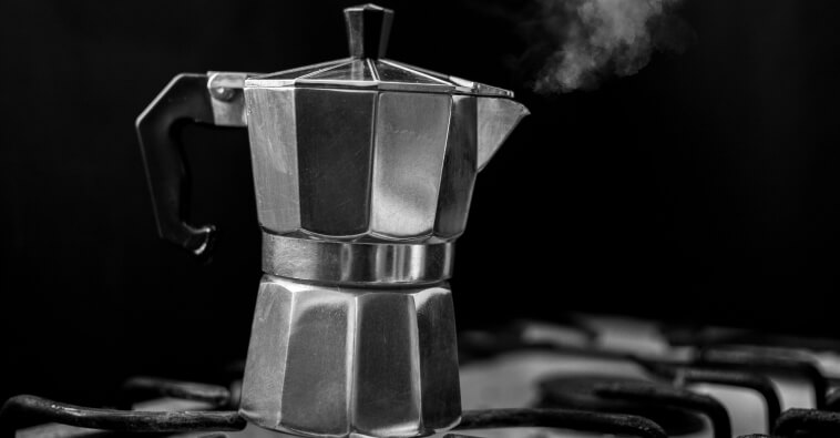Photo d'une machine à café italienne Bialetti fumante sur une gazinière.