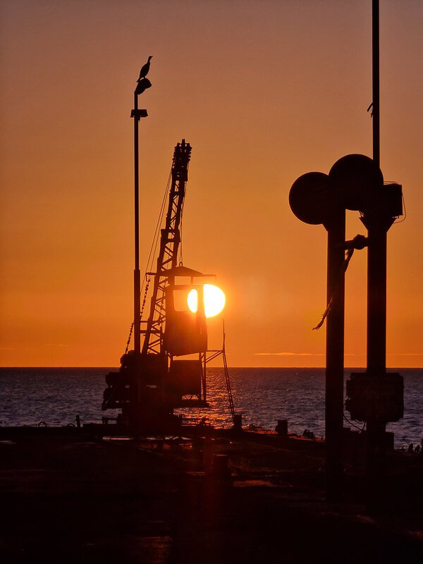 Coucher de soleil sur un port, grue en contre-jour avec un cormoran, prise avec un Galaxy S22